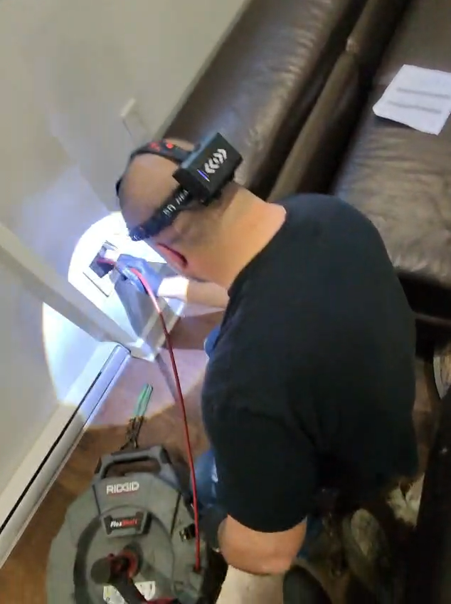 Technicien effectuant le nettoyage mécanique d'un drain avec un système RIDGID FlexShaft dans une résidence à Montréal.