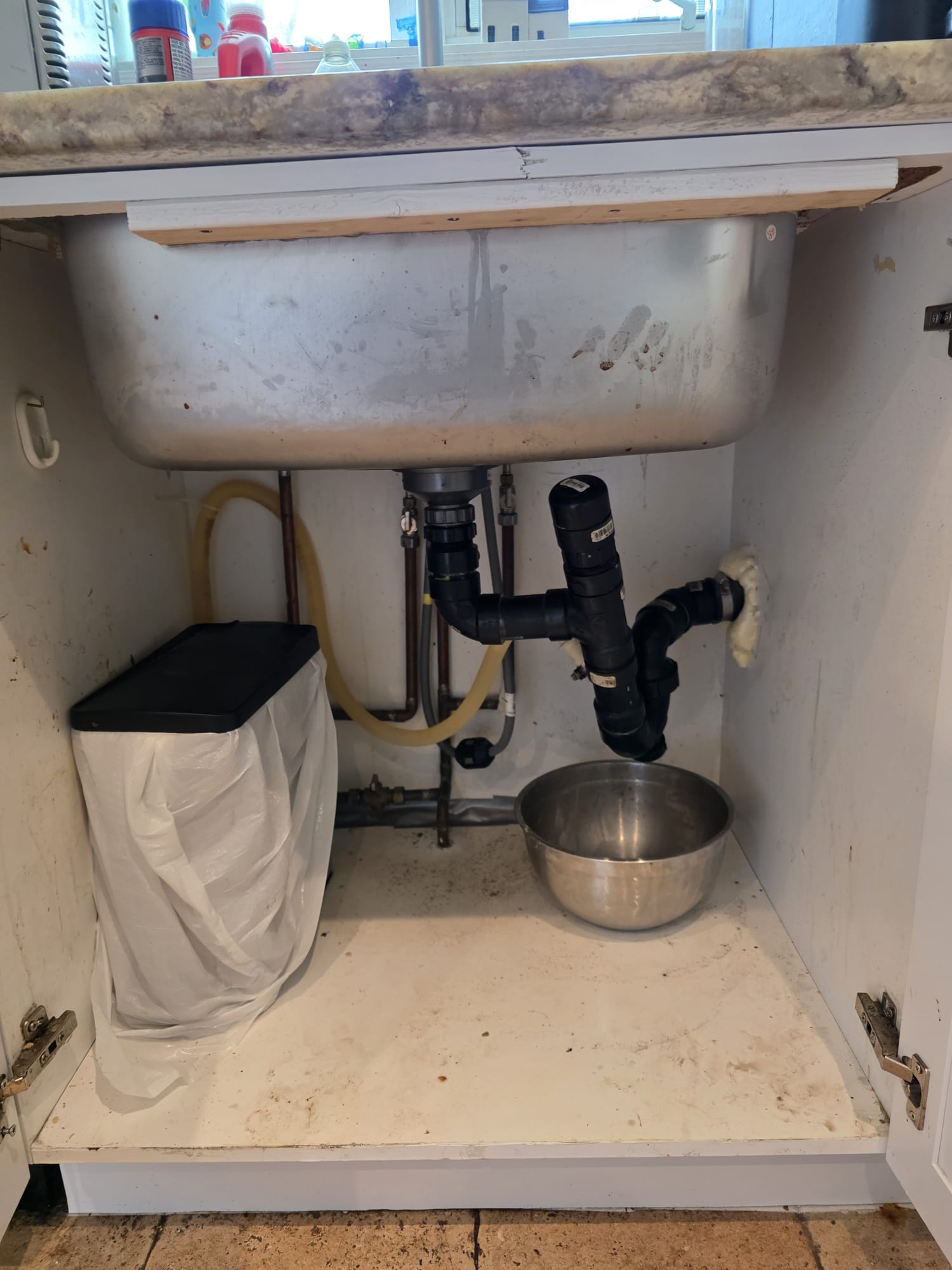 Inspection sous un évier de cuisine bouché à Montréal avant un débouchage professionnel