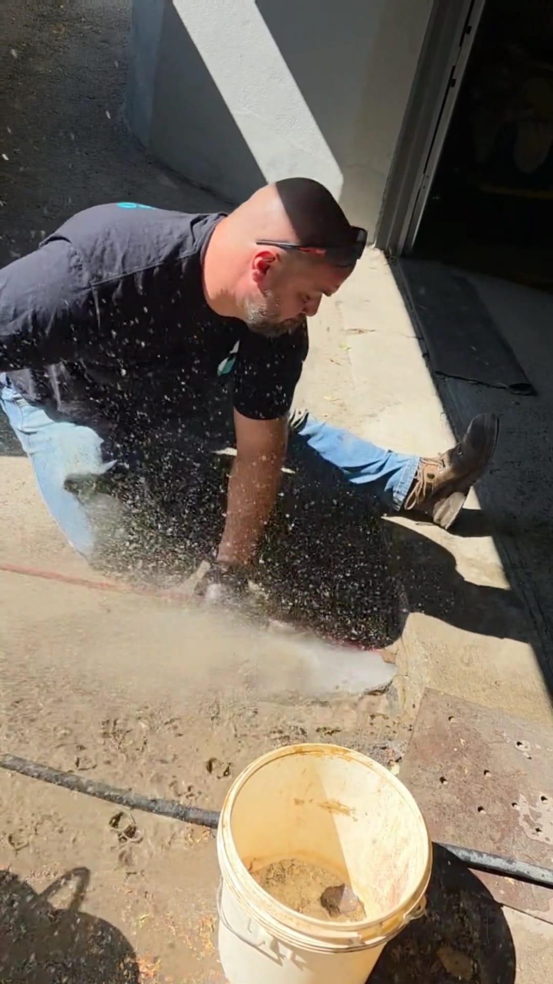 Technicien Flow Pro au travail avec un boyau à un accès extérieur de conduite.