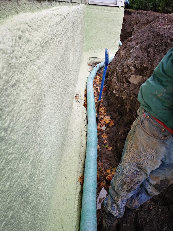 Drain français exposé le long d’une fondation pendant une excavation