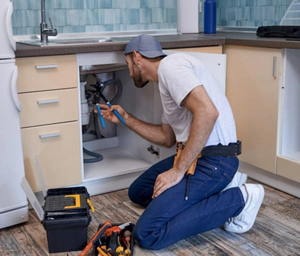 img-plumber-checking-under-sink-pipes-restaurant-sanitary-compliance